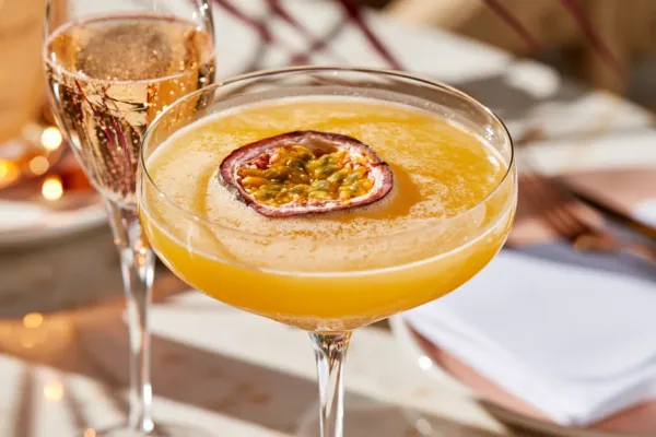 Nahaufnahme eines Pornstar Martini Cocktails mit einem Glas Proscecco daneben